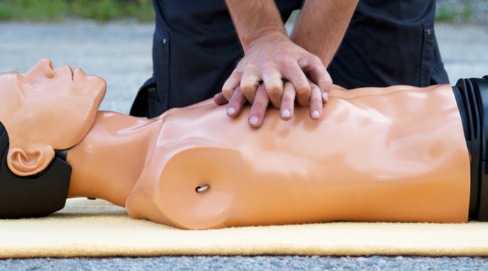 Person administering CPR on a manikin