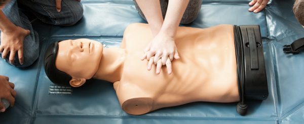 Person administering CPR on a manikin